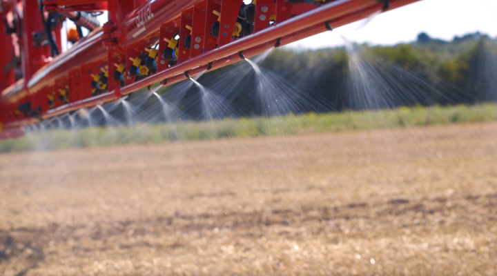 Miravis® Neo being applied to a field with a red spraying vehicle.